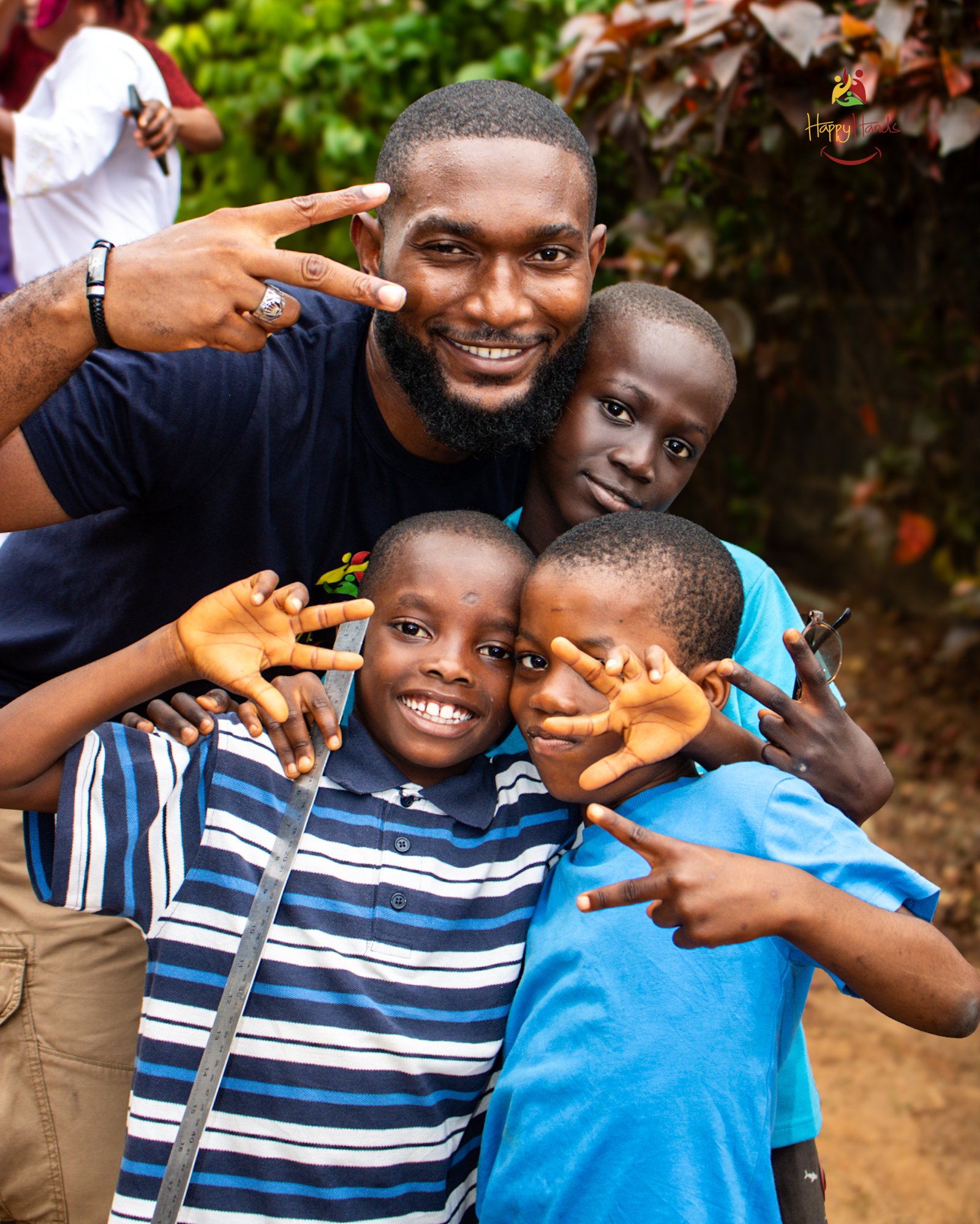 Volunteer smiling with three boys